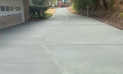 Thumbnail control image for Freshly poured concrete driveway leading to a residential home surrounded by trees.