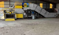 Thumbnail control image for Industrial processing machine with yellow and grey parts inside a large warehouse with metal roof beams.