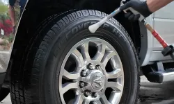 Thumbnail control image for Person cleaning silver alloy wheel and tire on gray Ram 2500 truck with tire shine applicator.