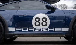 Thumbnail control image for Side view of a blue Porsche sports car with race number 88 and large rear spoiler under cloudy sky.