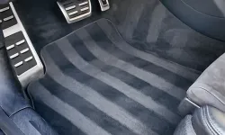 Thumbnail control image for Car interior floor showing black striped floor mat and metallic accelerator and brake pedals.