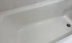 Thumbnail control image for Clean white bathtub with white tiled walls and soap holder over hexagonal patterned bathroom floor tiles.