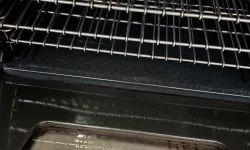 Thumbnail control image for Interior view of a clean oven with metal racks and a transparent door window showing some residue.