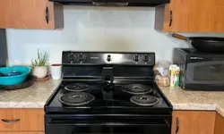 Thumbnail control image for A black stove with a matching range hood cleaned by MaidPro in a wooden kitchen setting, featuring cooking appliances and decor.