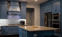 Thumbnail control image for Modern kitchen with blue cabinetry, marble island, stainless steel appliances, and recessed lighting.