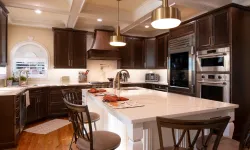 Thumbnail control image for Modern kitchen with dark wood cabinets, white island countertop, stainless steel appliances, and pendant lights
