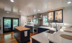 Thumbnail control image for Modern kitchen with navy blue cabinets, wooden island, marble countertops, stainless steel appliances, and large windows.