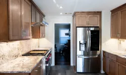 Thumbnail control image for Bright modern kitchen with marble countertops, wooden cabinets, stainless steel refrigerator, and gas stove.