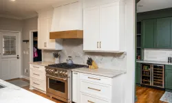 Thumbnail control image for Modern kitchen with white cabinets, stainless steel stove, wooden range hood, and green cabinetry with wine cooler.