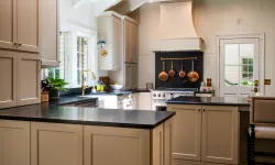 Thumbnail control image for Modern kitchen with beige cabinets, black countertops, copper pots, and large windows letting in natural light