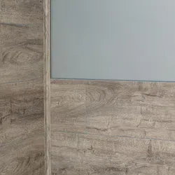 Corner wall covered with light brown wood-look tiles and upper portion painted light gray in modern interior.
