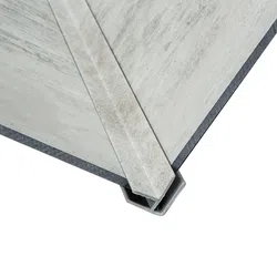 Close-up of a metal corner protector installed on a concrete wall edge, isolated on white background