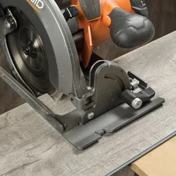 Close-up of a circular saw cutting through a wooden board during woodworking project.