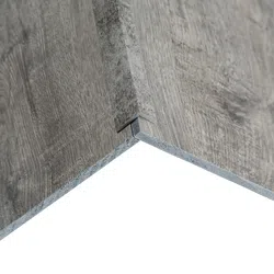 Close-up of interlocking gray wood-look laminate flooring panels with textured grain finish.