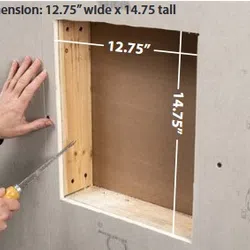 Person cutting drywall with a saw, showing an opening measuring 12.75 inches wide by 14.75 inches tall.