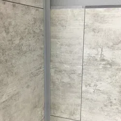 Close-up of gray textured wall panels with metal framing and visible seams in industrial style design.