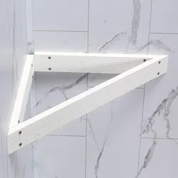 White triangular wooden shelf bracket mounted on a marble-patterned wall with screws.
