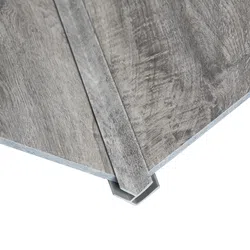 Close-up of gray wood textured vinyl flooring planks with interlocking edges on a white background