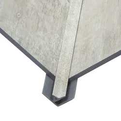 Close-up of two beige ceramic floor tiles joined by a matching corner trim piece with grey edge.