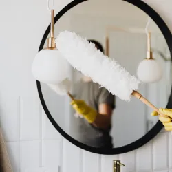 woman cleaning bathroom with duster