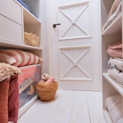 a room with a bed and a shelf with a basket and a basket