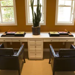 a desk with a chair and a chair in front of a window