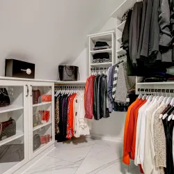 a master closet with clothing hanging on racks