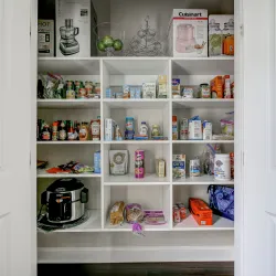 white painted pantry filled with food items and kitchen appliances