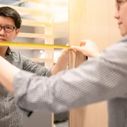 a man holding  yellow measuring tape