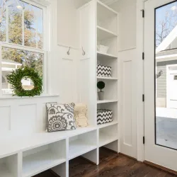 a mudroom painted white with a handbag hanging on a hook