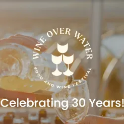 A person pouring white wine from a bottle into a glass for the Chattanooga Wine Over Water Festival in its 30th year