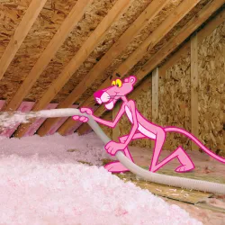 a pink ribbon tied to a wooden fence