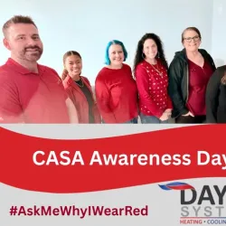 Group of six people wearing red shirts for CASA Awareness Day with Dayco Systems logo and hashtag #AskMeWhyIWearRed.