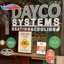 Dayco Systems Heating & Cooling logo on glass door with awards, safe place sign, and no soliciting notice