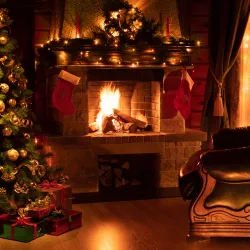 a fireplace with a christmas tree and presents in front of it