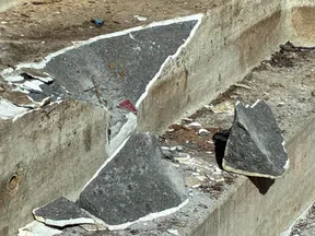 Broken concrete and red tile debris on worn concrete steps with red patterned tiles on wall above.