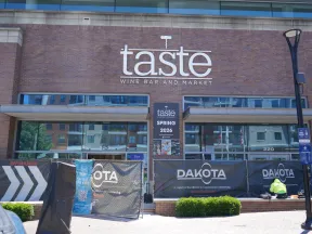 Taste Wine Bar and Market storefront with signage and construction barriers in front during daylight.
