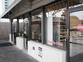 Exterior view of Murphy Beds showroom with large glass windows displaying furniture and store hours on door.