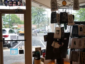 Gift shop interior featuring hanging and displayed decorative towels by a glass door with parking lot view outside