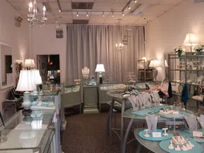 Interior view of a bright jewelry store with multiple display cases and elegant lighting fixtures.