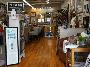 Interior view of a custom framing shop with picture frames, art, and memorabilia on display