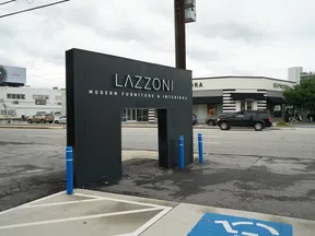 Lazzoni Modern Furniture & Interiors black sign near street with Sephora store and cars in background on cloudy day