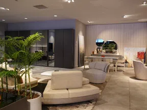 Modern living room with beige curved sofas, indoor plants, round mirrors, and a sleek dining area in soft lighting.