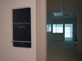 Office door sign for The White Rose Society, room 214, with a dimly lit hallway and office visible inside.