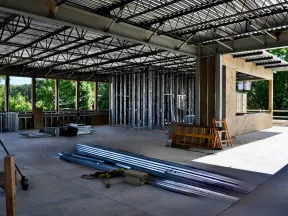 Interior of a partially constructed commercial building with metal framing and open ceiling beams.
