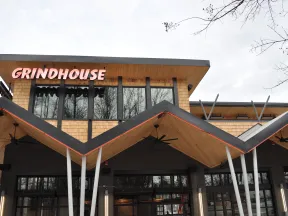 Modern Grindhouse cafe exterior with distinctive zigzag wooden roof and large windows on overcast day