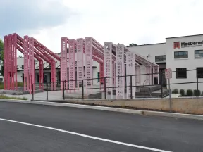 Pink metal architectural installation outside MacDermid Graphics Solutions building on a cloudy day