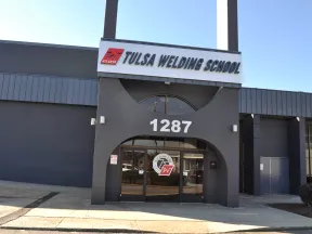 Front entrance of Tulsa Welding School building with clear signage and address 1287 on a sunny day.