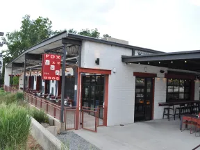 Exterior view of Fox Bros BBQ restaurant with outdoor seating and red signage on a bright day.