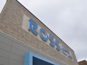 Blue Ross Dress for Less sign on a brick and gray store exterior under cloudy sky.